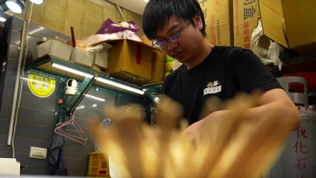 Taiwanese vendor expertly preparing delicious cheese filled crepes at a busy night market food stall