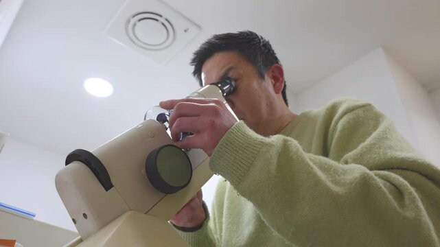 Asian man making and checking the prescription of glasses with a lensmeter in an optical center
