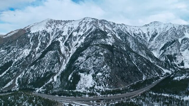 Frisco Gulch rugged mountain ridge with snow covered slopes and forested valleys, aerial drone overview
