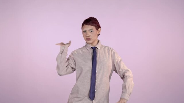 Playful young non-binary person dancing and posing on pink background