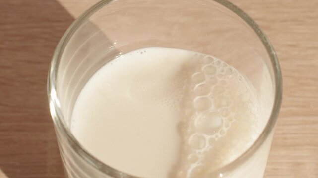 High Angle Close Up Pouring Fresh Milk Into Glass, Daily Breakfast Drink And Healthy Dairy Nutrition Concept