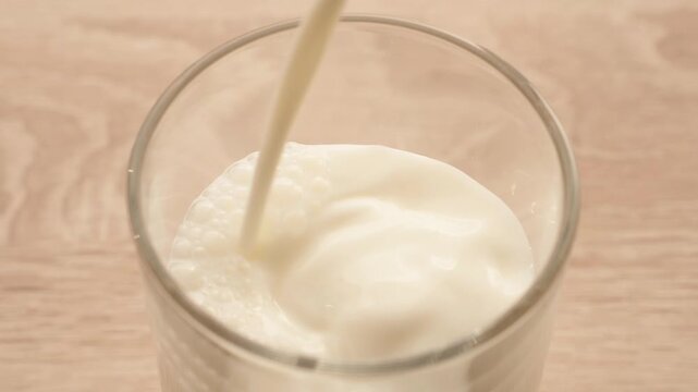 Slow Motion Pouring Milk Into Glass, Healthy Dairy Drink And Modern Nutrition Concept