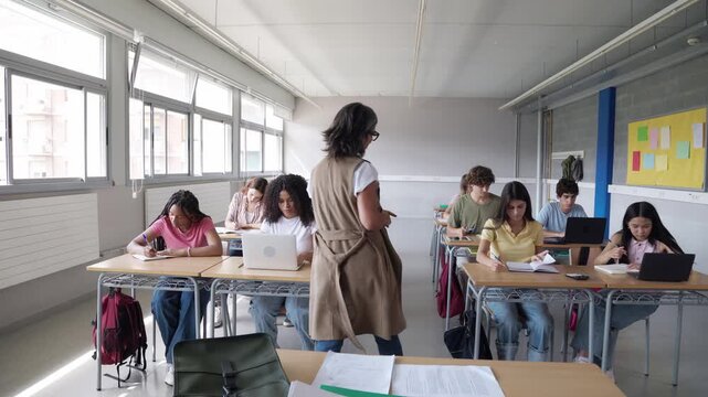 High school teacher walking through classroom of diverse students