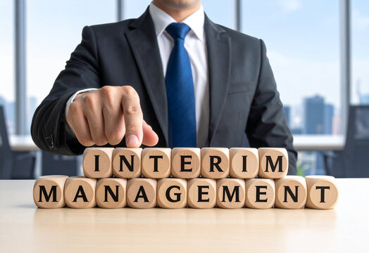 Interim Management - Geschäftsmann zeigt auf den Text "Interim Management"