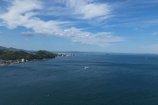 Aerial drone photo of Kanmon Strait with coastal town and vessel, Shimonoseki, Japan
