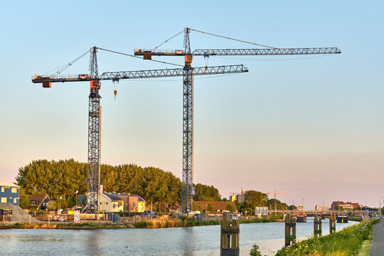 Urban Development And Construction Site With Tower Cranes Along the Noordhollands Canal In Alkmaar, Netherlands, At Sunset, Infrastructure, Real Estate, Engineering, Modernization