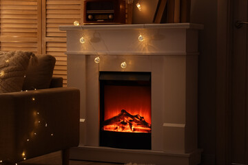 Naklejka premium Fireplace with glowing lights in dark living room