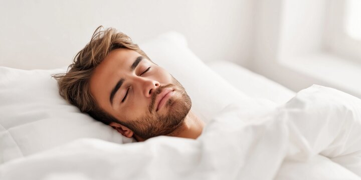 Young man peacefully sleeping in a white bed, relaxed and serene