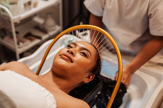 Southeast Asian woman enjoying hydrotherapy at a Japanese head spa with water halo rinse for scalp relaxation, hydration, and wellness.