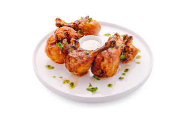 Fototapeta premium Grilled chicken pieces served with sauce on a white plate with herbs