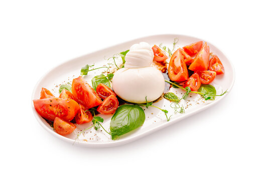 Fresh burrata and tomato salad served on a white plate