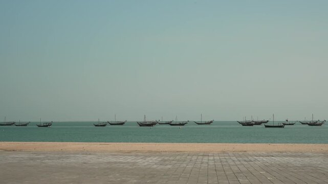 Traditional Qatari Dhow Boats Anchored in the Turquoise Sea at Katara Cultural Village, Doha, Qatar.