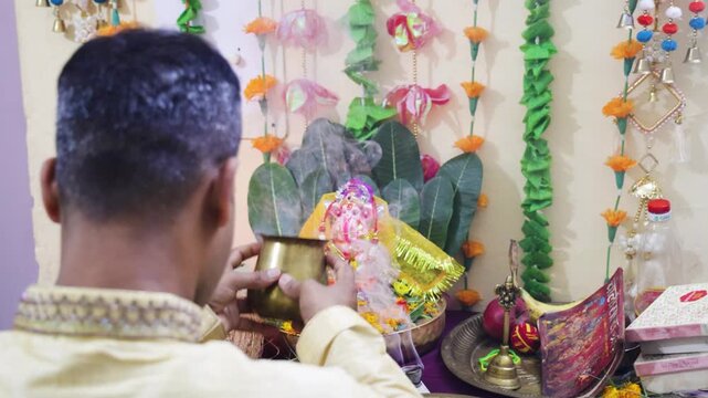 traditional ganesh puja ceremony performed by indian devotee at home
