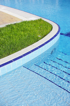 Blue pool filled with water in Summer