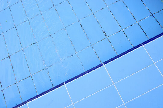 Blue pool filled with water in Summer