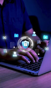 A businessman works on his laptop at home with a virtual display showing a symbol to signify cyber security privacy and online data protection&nbsp;
