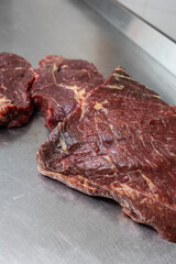 Fototapeta premium Close-up of raw beef primal cut and steaks on stainless steel