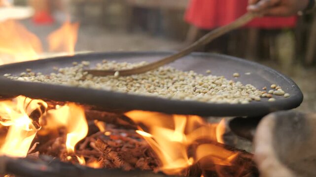 Une femme fait cuire des grains de caf&eacute; dans une casserole au-dessus d&rsquo;un feu ext&eacute;rieur, en &Eacute;thiopie 