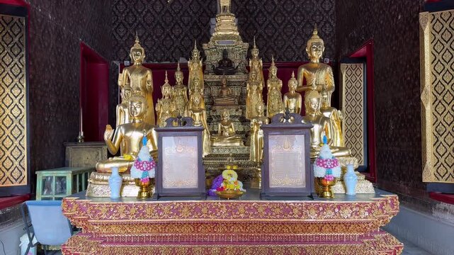 Golden Buddha statues in traditional temple at Grand Palace in Bangkok Thailand. Ornate spiritual interior with sacred figures, decorative patterns and historic Buddhist architecture in Southeast Asia