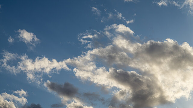Dramatic illuminated clouds shining against a deep blue sky.