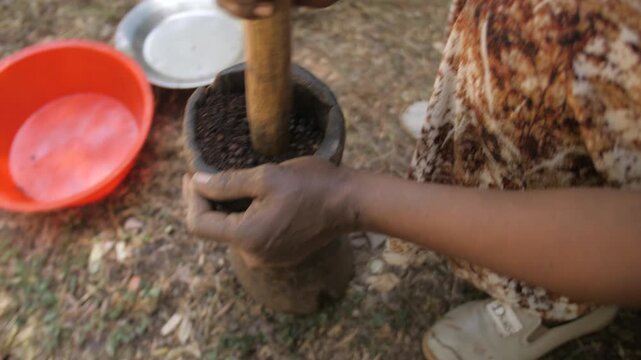 Une femme broie et &eacute;crase le caf&eacute; cuit dans un pilon, en Ethiopie