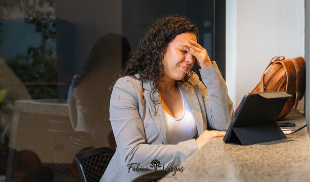 Woman experiencing work stress, frustration, and headache
