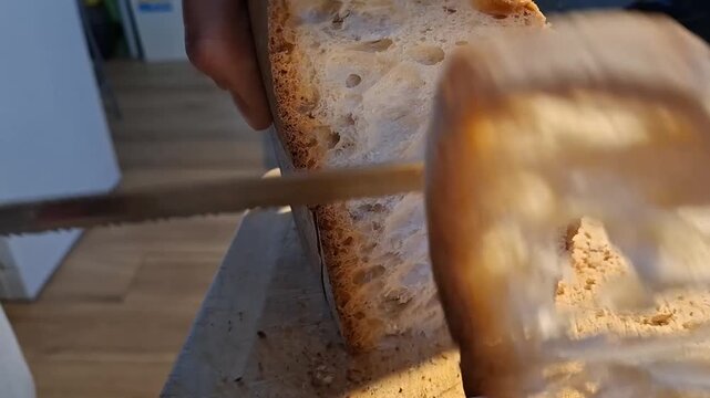 Close Up of Man Slicing Crunchy Rustic Italian Bread with Large Air Holes