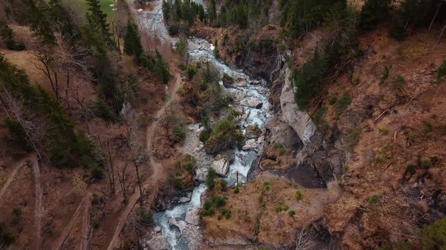 Aerial: river near Pochtenkessel deep rock funnel during the day near Adelboden, canton of Bern, Switzerland, establishing drone shot