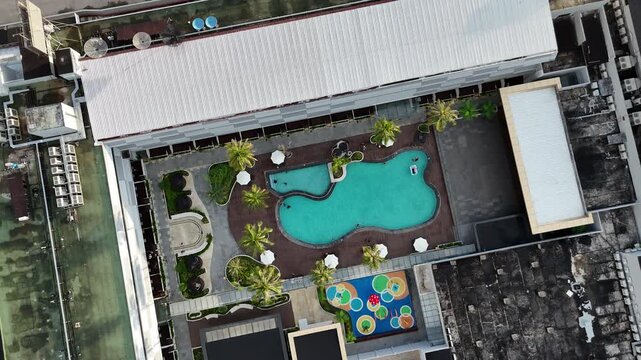 A view from above the swimming pool in the hotel area and the tropical gardens at an urban resort.