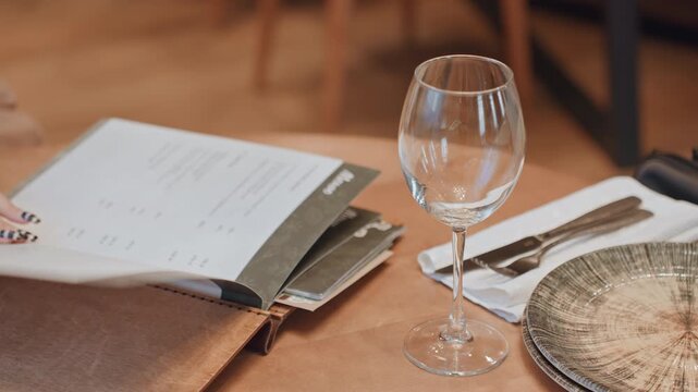 Refined woman considers food options slowly. Graceful lady thoughtfully examines menu in elegant setting. Sophisticated woman carefully studies menu amidst refined restaurant atmosphere