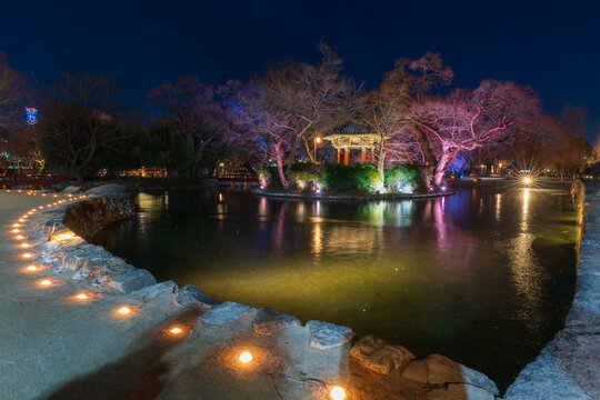 Serene twilight view of the illuminated Gwanghallu Pavilion overlooking a calm pond surrounded by bare winter trees and glowing ground lanterns in Namwon.