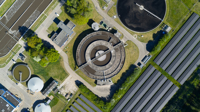 Aerial view of the RWZI Echten water treatment plant featuring circular sedimentation tanks and extensive solar panel arrays Hoogeveen, Drenthe, Netherlands.
