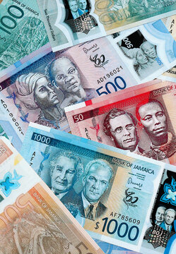 Jamaican dollar money banknotes pile on table. Jamaica bills of JMD currency close up
