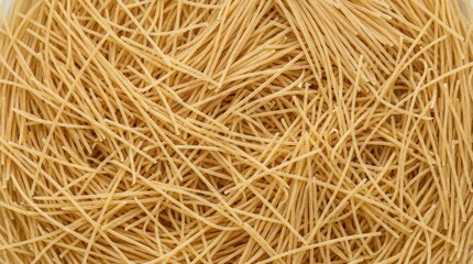 Obraz premium Overhead view of fine, dry, uncooked angel hair pasta forming a dense, interwoven background with a warm golden brown color and delicate texture