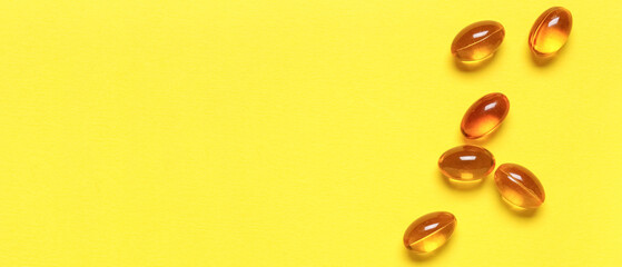 Obraz premium Vitamin E pills on yellow background, closeup