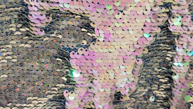 macro texture of pink holographic flip sequins on fabric