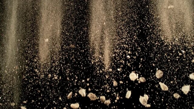 Super Slow Motion Shot of Falling Soil with Rocks on Black Background at 1000fps.