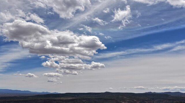 4K timelapse captures a unique linear array of clouds drifting across the horizon. Cinematic atmospheric motion reveals symmetrical patterns and organized textures within a shifting cloudscape.