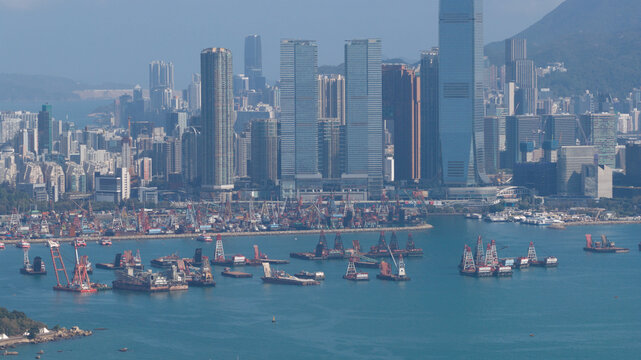 Aerial view of the dense West Kowloon skyline featuring the International Commerce Centre and cargo barges in the harbour on a clear day Hong Kong, Hong Kong.