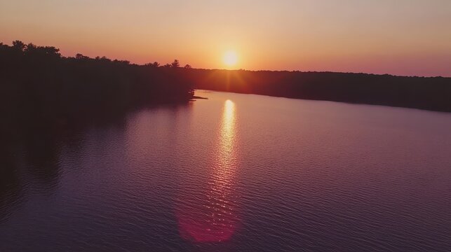 A Vibrant Sunset Casting Warm Golden Light and Colors Over a Peaceful Lake at Dusk