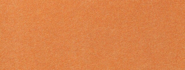 Fototapeta premium Orange suede fabric background with matte microfiber texture, soft apricot felt surface, macro