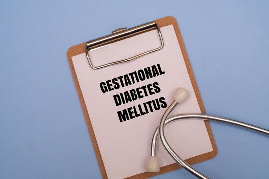A clipboard with GESTATIONAL DIABETES MELLITUS text and stethoscope on a coloured background. Concept for pregnancy health, maternal care, and prenatal screening for high blood sugar