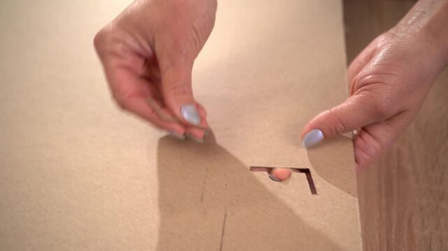 Female Hands assembling a brown cardboard box, top view. process of sustainable business and eco-friendly logistics