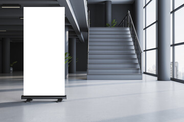 Naklejka premium Blank rollup banner mockup standing in modern interior hallway with stairs and large windows in clean contemporary building space. 3D Rendering