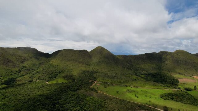 Aerial Drone View of Lush Green Hills Under Dramatic Cloudy Sky in Tropical Landscape