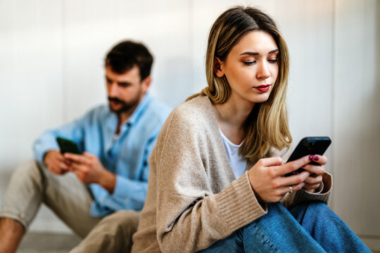 Two people, couple absorbed in their phones illustrate social media addiction, digital distraction
