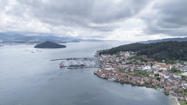 Aerial view of the historic fishing village of Combarro and its marina along the calm waters of the bay under a cloudy sky Combarro, Pontevedra, Spain.