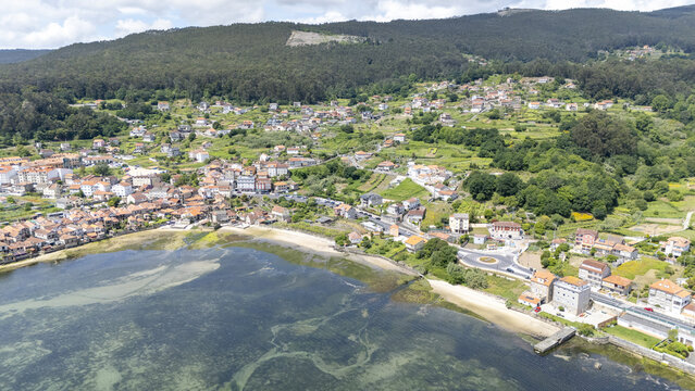 Aerial view of the historic coastal village featuring traditional stone houses along the shoreline and lush green hills Combarro, Pontevedra, Spain.