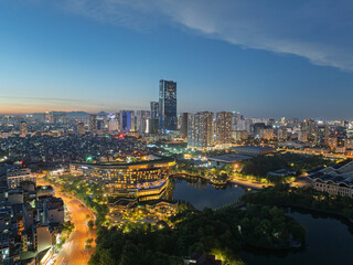 Twilight aerial panorama of modern Hanoi skyline with illuminated buildings, lakes, and vibrant urban districts during blue hour. © Hanoi Photography