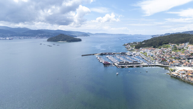 Aerial view of the marina and coastal town of Combarro with the island of Tambo in the Ria de Pontevedra under a cloudy sky Combarro, Pontevedra, Spain.